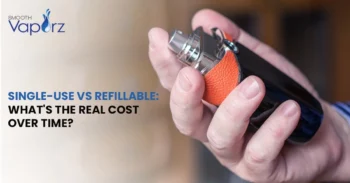Hand holding a sleek refillable vape device with orange grip, alongside text comparing the cost of single-use vs refillable vapes.